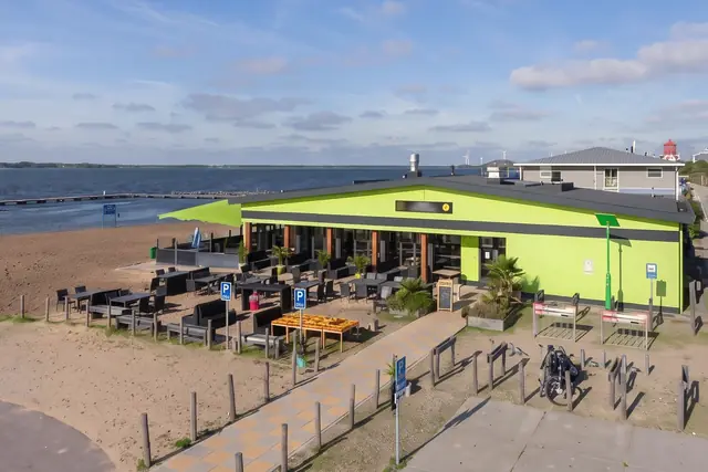 Het terras van het paviljoen aan het strand, overdag (AI-beeld van een eigen foto)